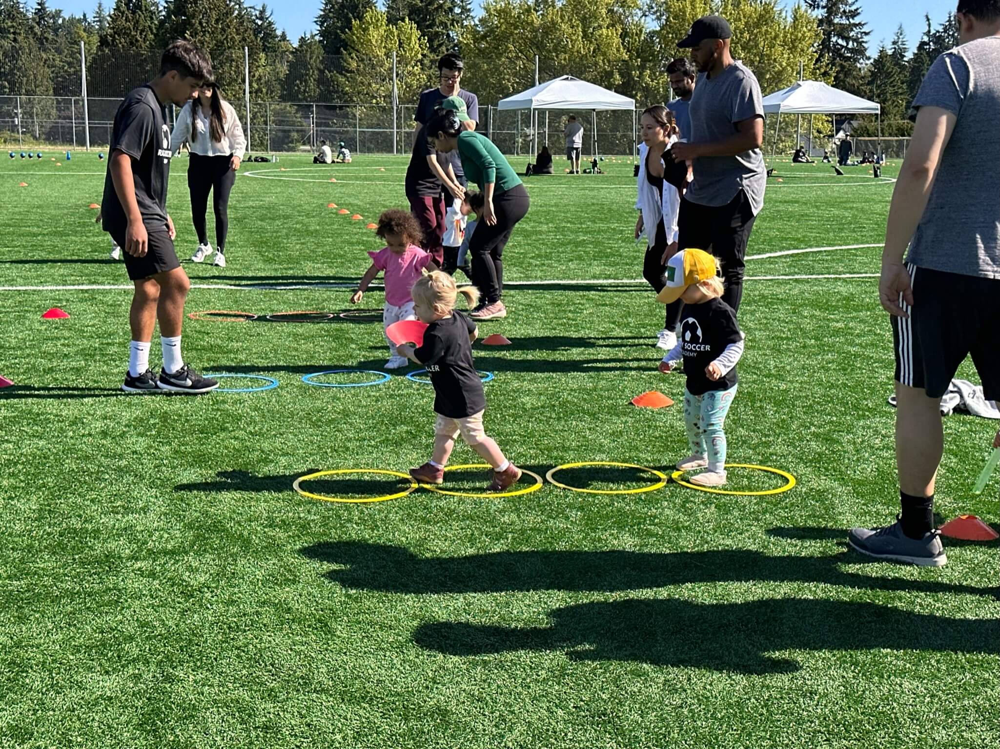 Toddlers doing a soccer obstacle course