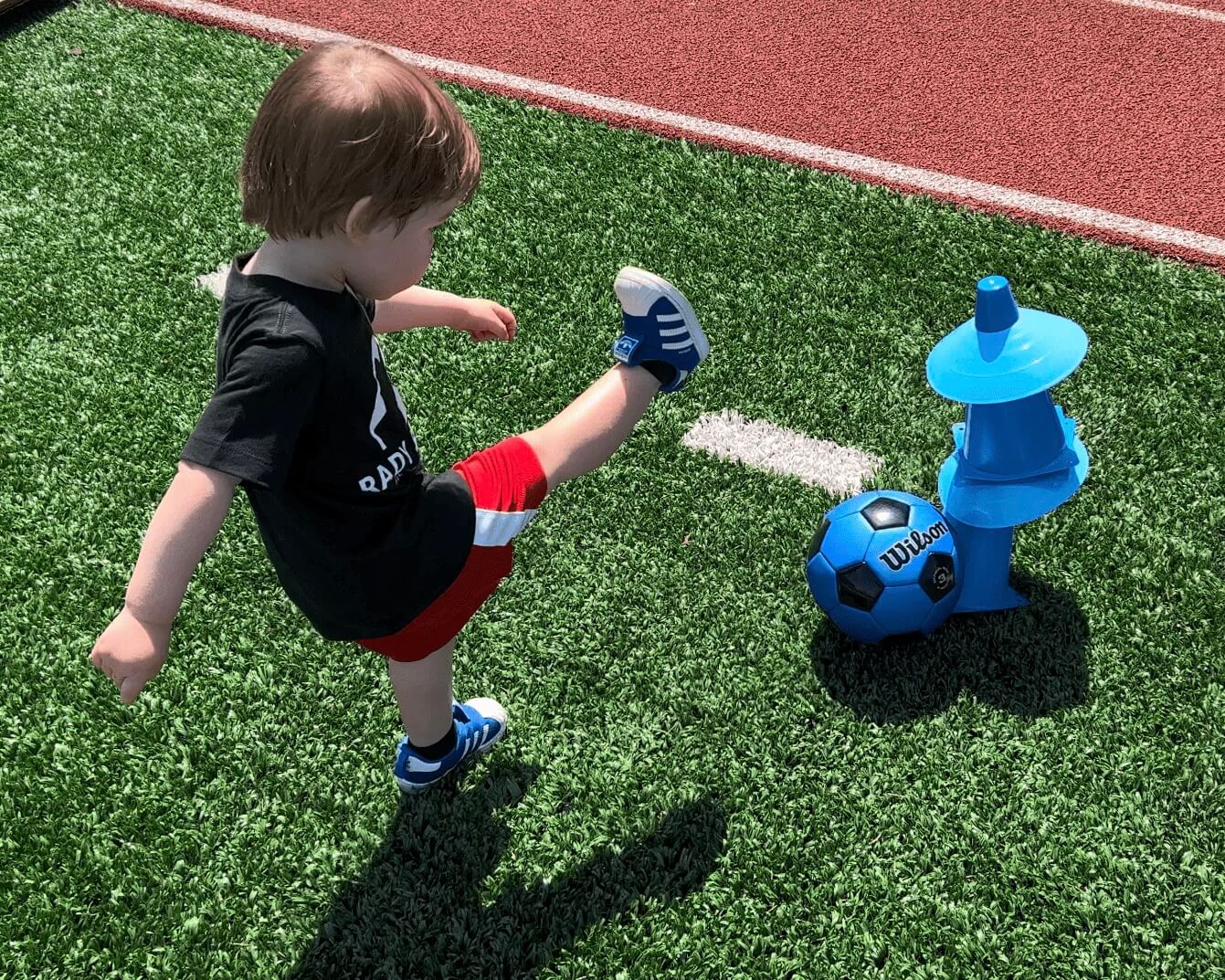 Toddler kicking down a cone